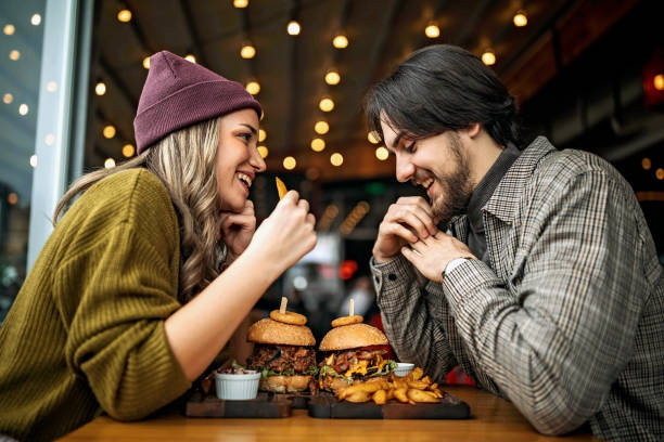 Foodie couple enjoying gourmet meal, discovering new cuisines and restaurants, ideal for finding culinary love and shared food adventures on a foodie dating site like BadsX.com.