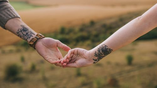 Tattooed couple showing off body art, finding partner who appreciates tattoo culture, ink, and self-expression, for unique connections on a tattoo enthusiasts dating site like BadsX.com.