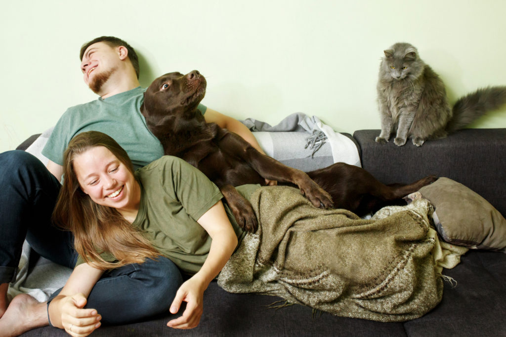 Couple embracing dog, showing shared love for furry friends. Ideal for animal lovers dating, finding true companionship with partner cherishing pets and animal welfare on BadsX.com.